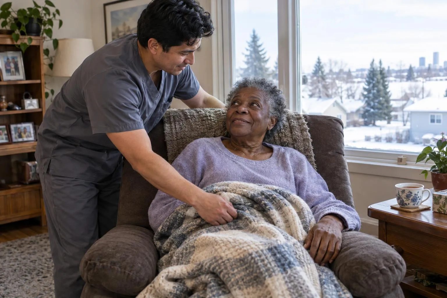 A caregiver helps an older woman settle into her recliner at home.